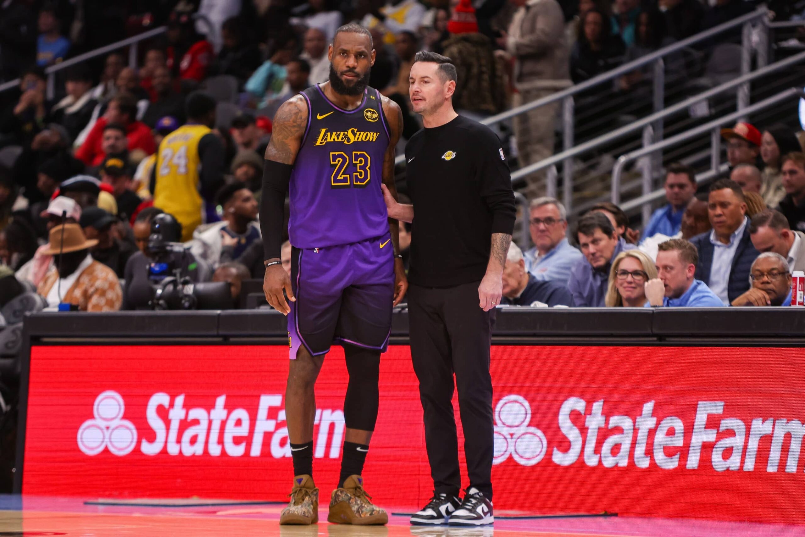 Los Angeles Lakers forward LeBron James (23) talks to head coach JJ Redick against the Atlanta Hawks in the second quarter at State Farm Arena.
