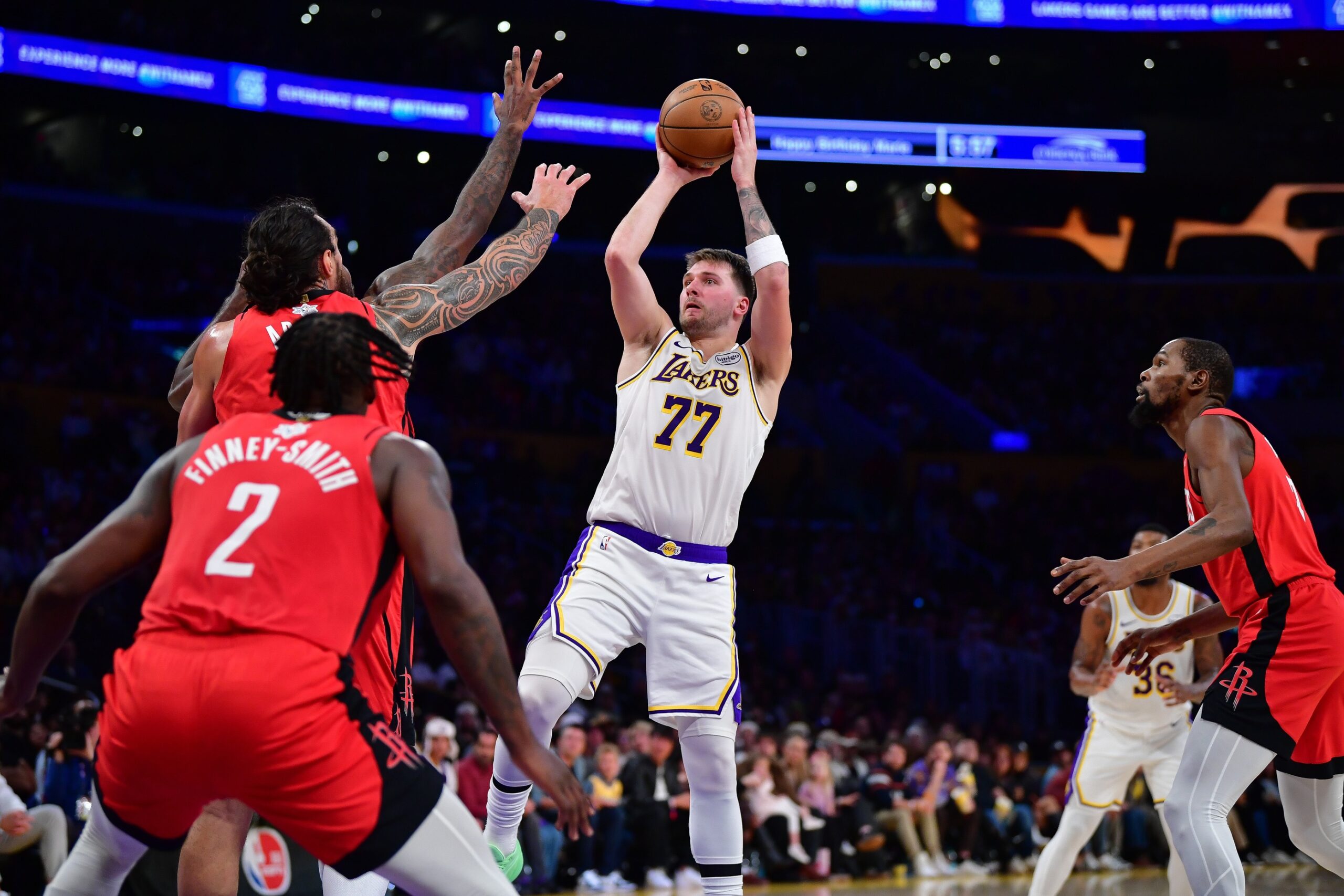 Dec 25, 2025; Los Angeles, California, USA; Los Angeles Lakers guard Luka Doncic (77) shoots against Houston Rockets center Steven Adams (12) during the first half at Crypto.com Arena. Mandatory Credit: Gary A. Vasquez-Imagn Images