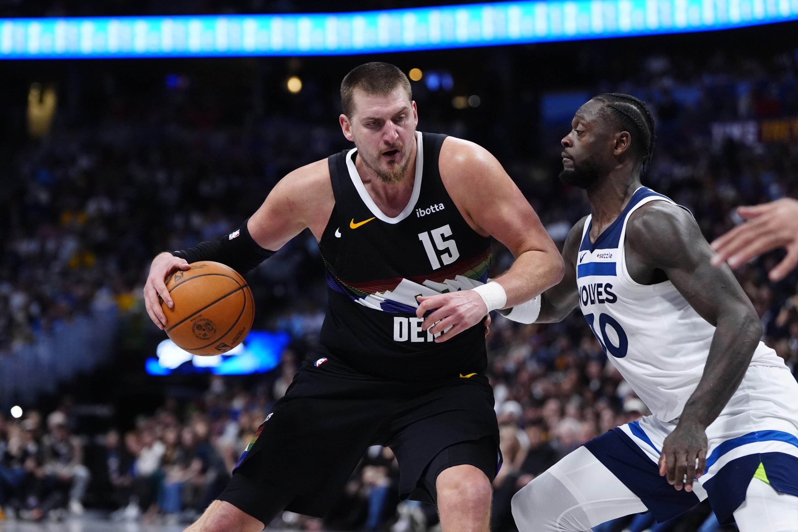 Dec 25, 2025; Denver, Colorado, USA; Minnesota Timberwolves forward Julius Randle (30) defends on Denver Nuggets center Nikola Jokic (15) at Ball Arena. Mandatory Credit: Ron Chenoy-Imagn Images