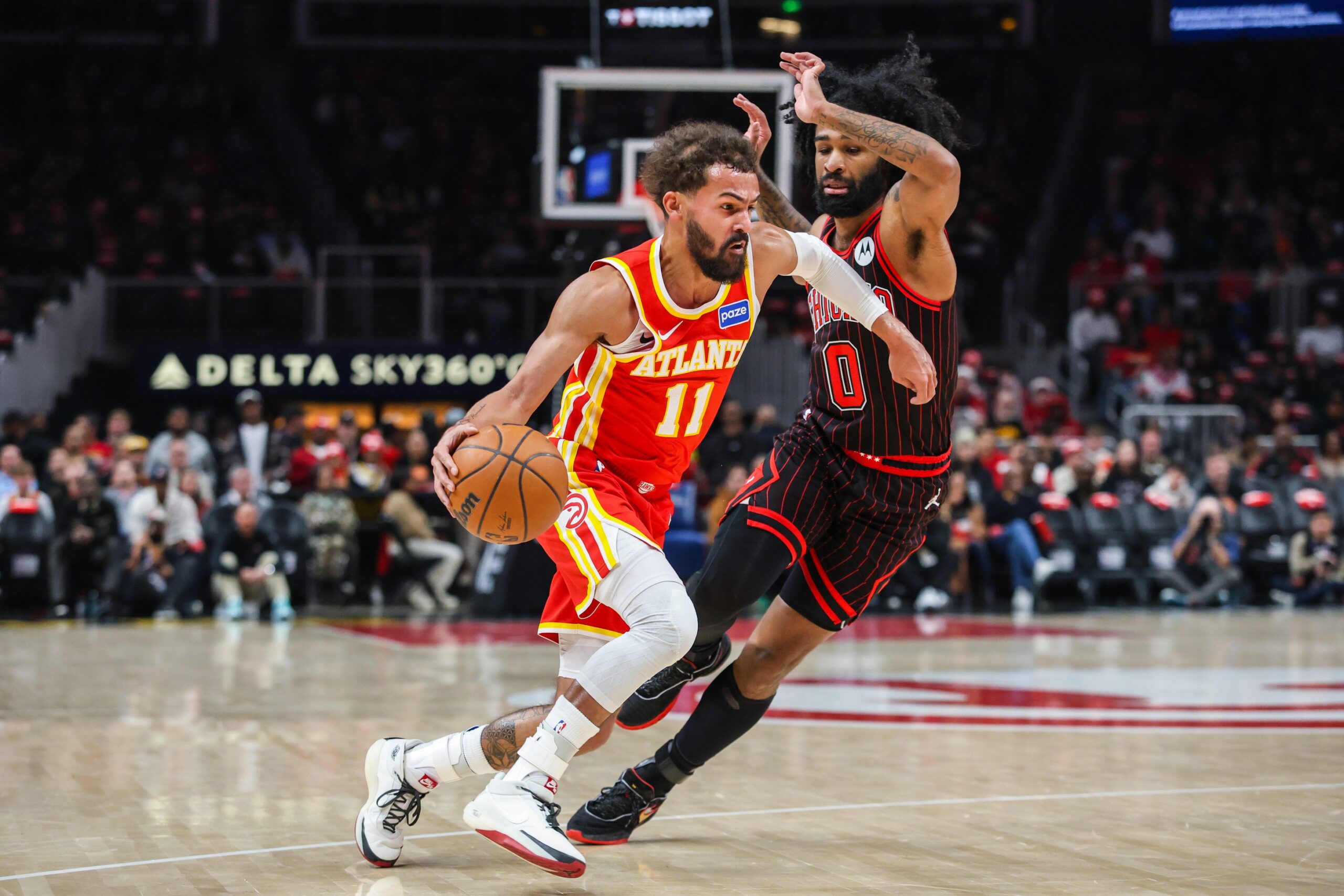 Dec 23, 2025; Atlanta, Georgia, USA; Atlanta Hawks guard Trae Young (11) dribbles the ball toward the basket against Chicago Bulls guard Coby White (0) during the first quarter at State Farm Arena. Mandatory Credit: Jordan Godfree-Imagn Images
