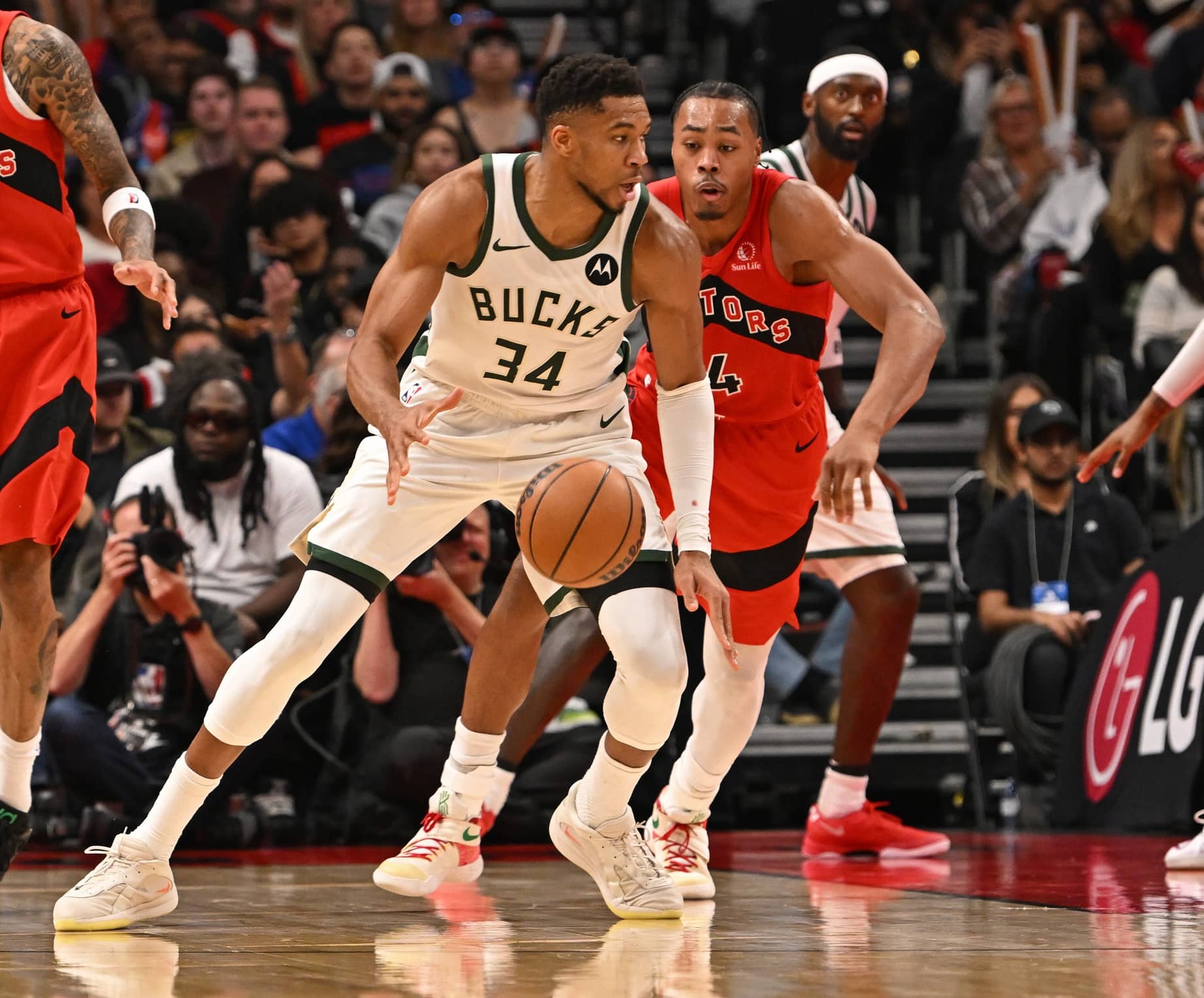 Oct 24, 2025; Toronto, Ontario, CAN; Milwaukee Bucks forward Giannis Antetokounmpo (34) is defended by Toronto Raptors forward Scottie Barnes (4) in the fourth quarter at Scotiabank Arena. Mandatory Credit: Gerry Angus-Imagn Images