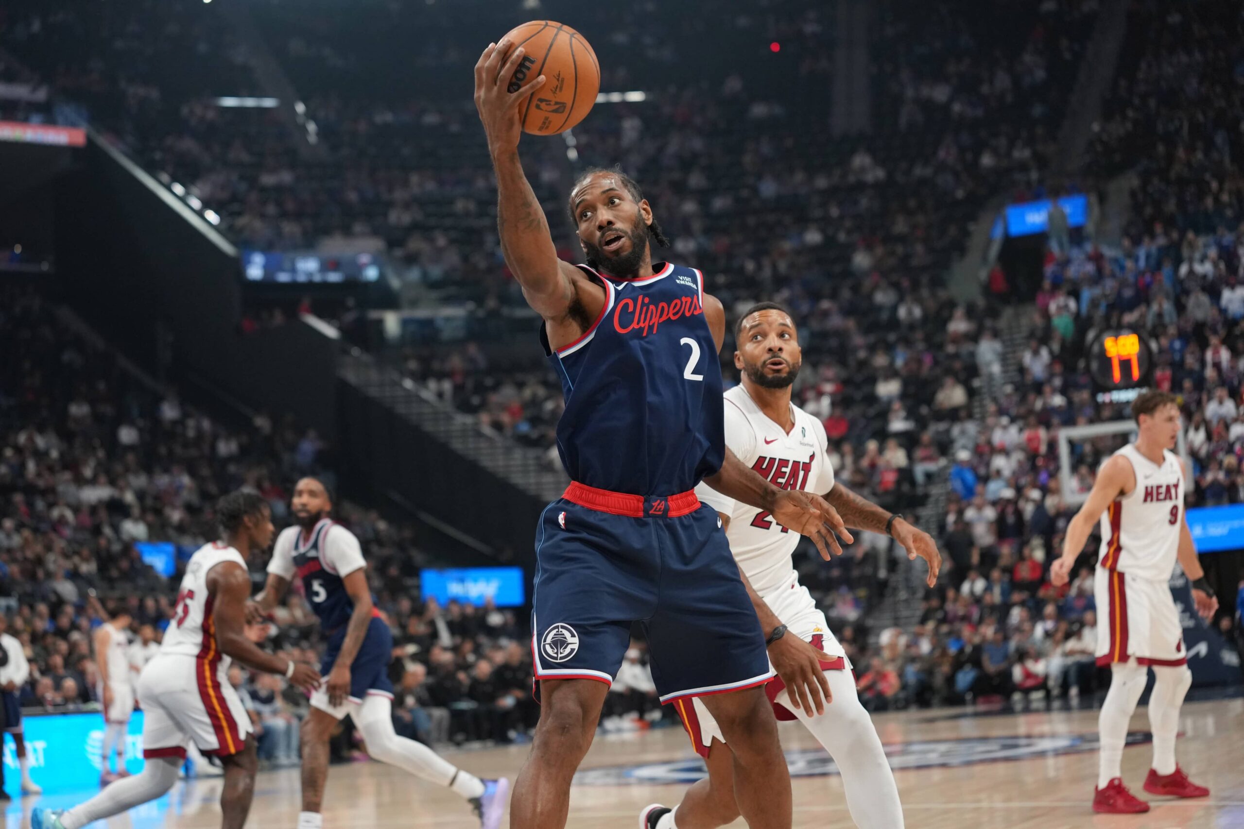 Nov 3, 2025; Inglewood, California, USA; LA Clippers forward Kawhi Leonard (2) reaches for the ball against Miami Heat guard Norman Powell (24) in the first half at Intuit Dome. Mandatory Credit: Kirby Lee-Imagn Images