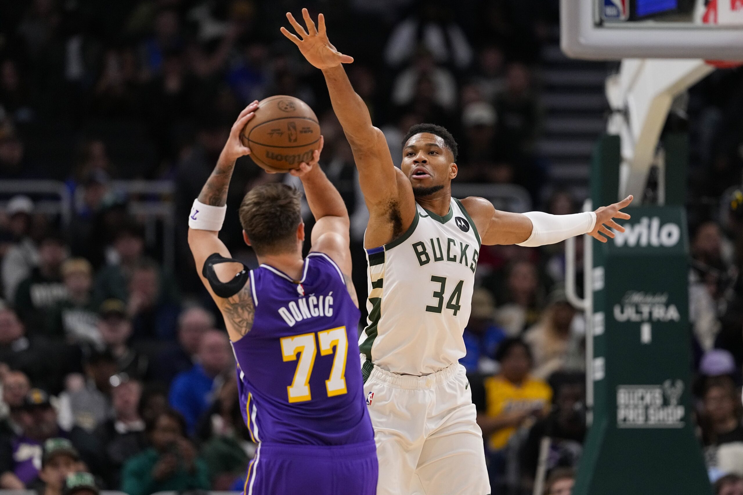 Nov 15, 2025; Milwaukee, Wisconsin, USA; Milwaukee Bucks forward Giannis Antetokounmpo (34) defends Los Angeles Lakers guard Luka Doncic (77) during the first quarter at Fiserv Forum. Mandatory Credit: Jeff Hanisch-Imagn Images