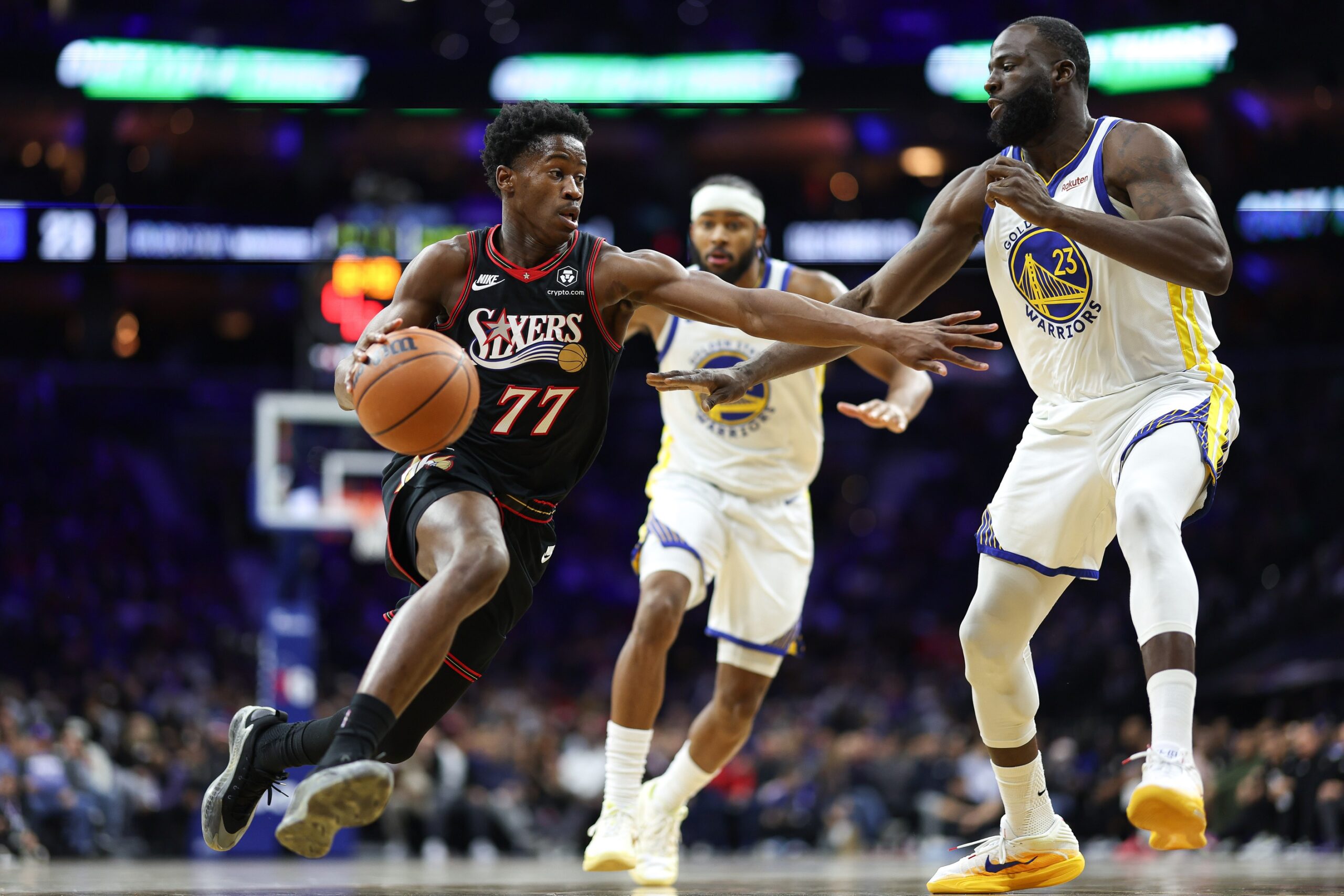 Dec 4, 2025; Philadelphia, Pennsylvania, USA; Philadelphia 76ers guard VJ Edgecombe (77) drives against Golden State Warriors forward Draymond Green (23) during the second quarter at Xfinity Mobile Arena. Mandatory Credit: Bill Streicher-Imagn Images