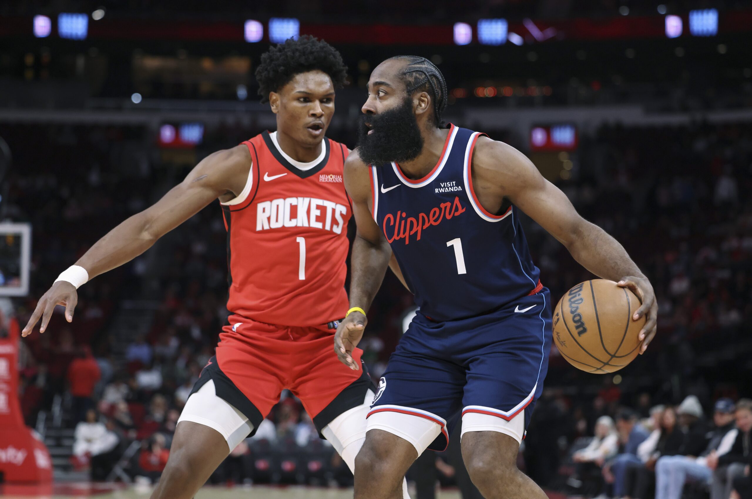 Dec 11, 2025; Houston, Texas, USA; Los Angeles Clippers guard James Harden (1) controls the ball as Houston Rockets guard Amen Thompson (1) defends during the first quarter at Toyota Center. Mandatory Credit: Troy Taormina-Imagn Images