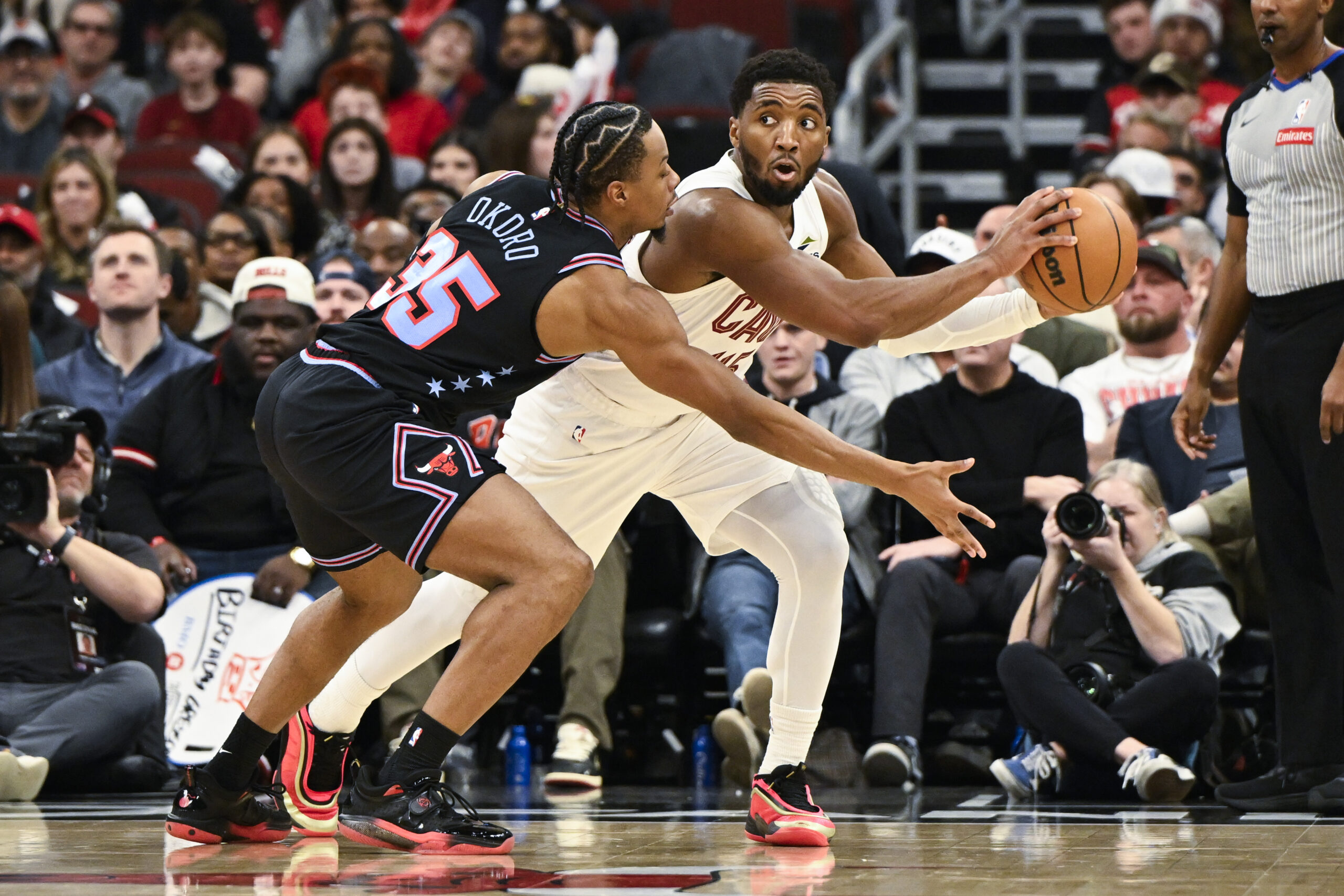 Dec 17, 2025; Chicago, Illinois, USA; Cleveland Cavaliers guard Donovan Mitchell (45) passes the ball away from Chicago Bulls forward Isaac Okoro (35) during the second half at United Center. Mandatory Credit: Matt Marton-Imagn Images