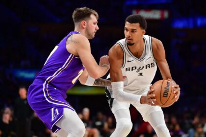 Nov 5, 2025; Los Angeles, California, USA; San Antonio Spurs forward Victor Wembanyama (1) controls the ball against Los Angeles Lakers guard Luka Doncic (77) during the second half at Crypto.com Arena. Mandatory Credit: Gary A. Vasquez-Imagn Images