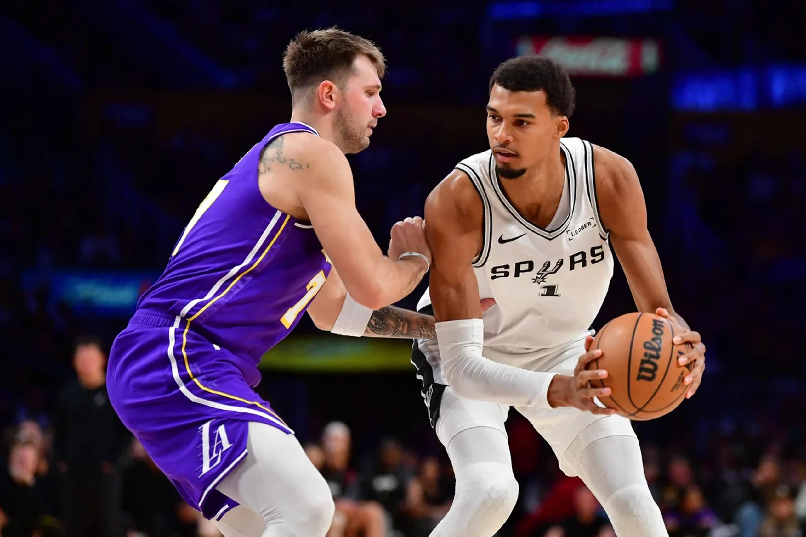 Nov 5, 2025; Los Angeles, California, USA; San Antonio Spurs forward Victor Wembanyama (1) controls the ball against Los Angeles Lakers guard Luka Doncic (77) during the second half at Crypto.com Arena. Mandatory Credit: Gary A. Vasquez-Imagn Images