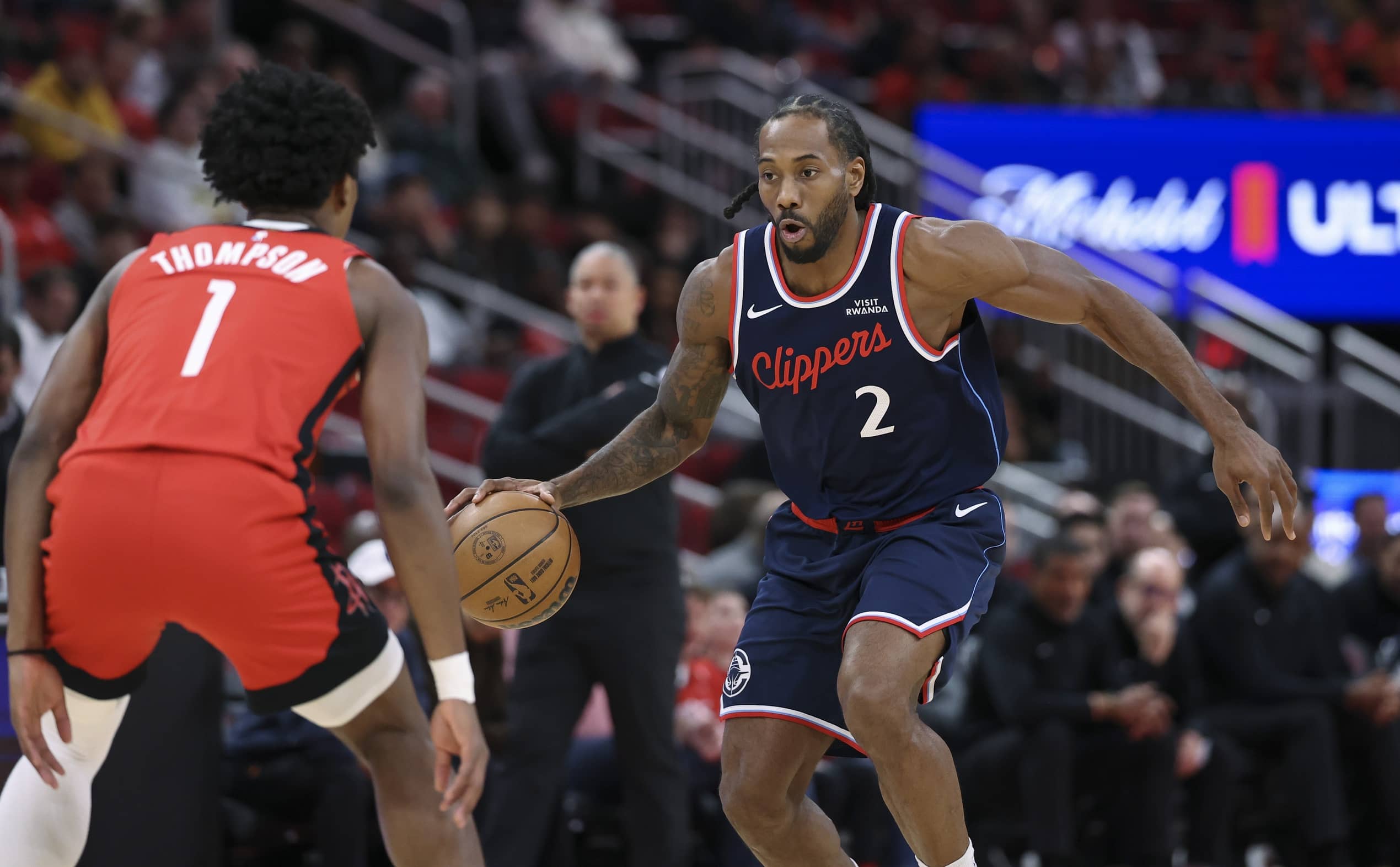 Houston, Texas, USA; Los Angeles Clippers forward Kawhi Leonard (2) dribbles the ball as Houston Rockets guard Amen Thompson (1) defends during the first quarter at Toyota Center. Mandatory Credit: Troy Taormina-Imagn Images