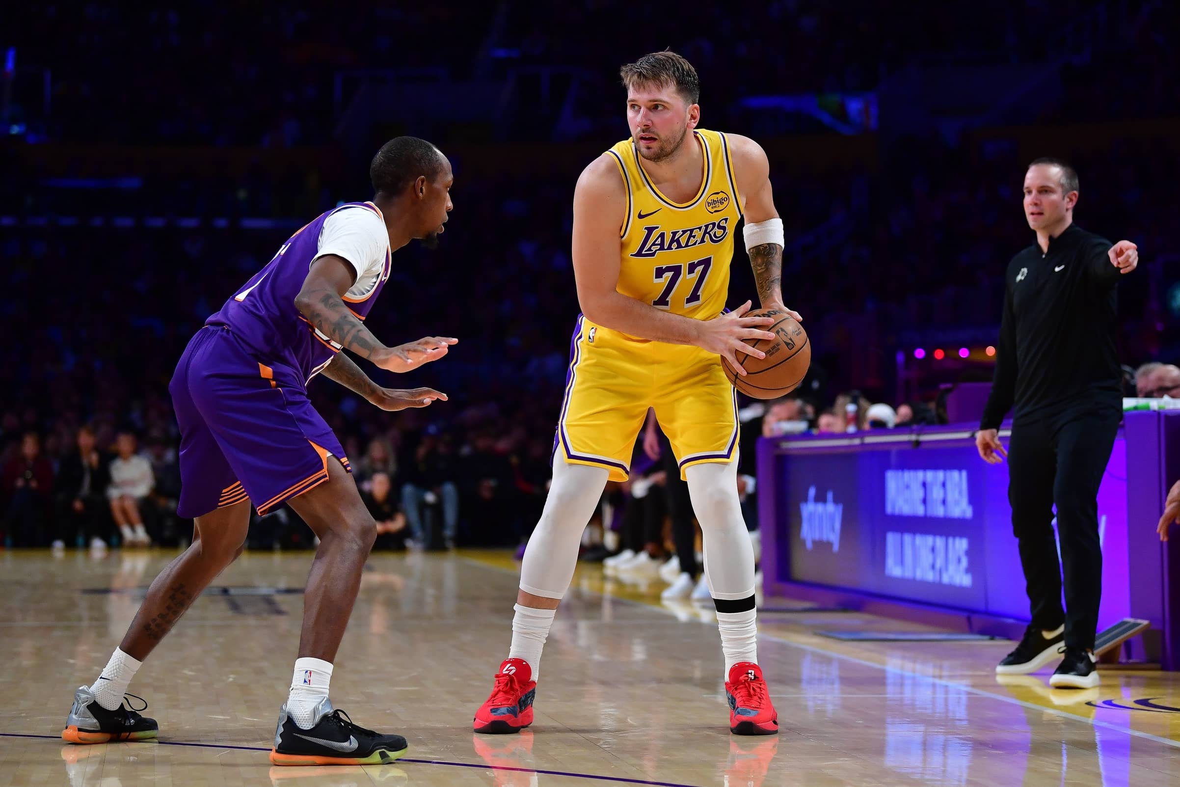 Los Angeles, California, USA; Los Angeles Lakers guard Luka Doncic (77) controls the ball against Phoenix Suns guard Jamaree Bouyea (17) during the second half at Crypto.com Arena. Mandatory Credit: Gary A. Vasquez-Imagn Images