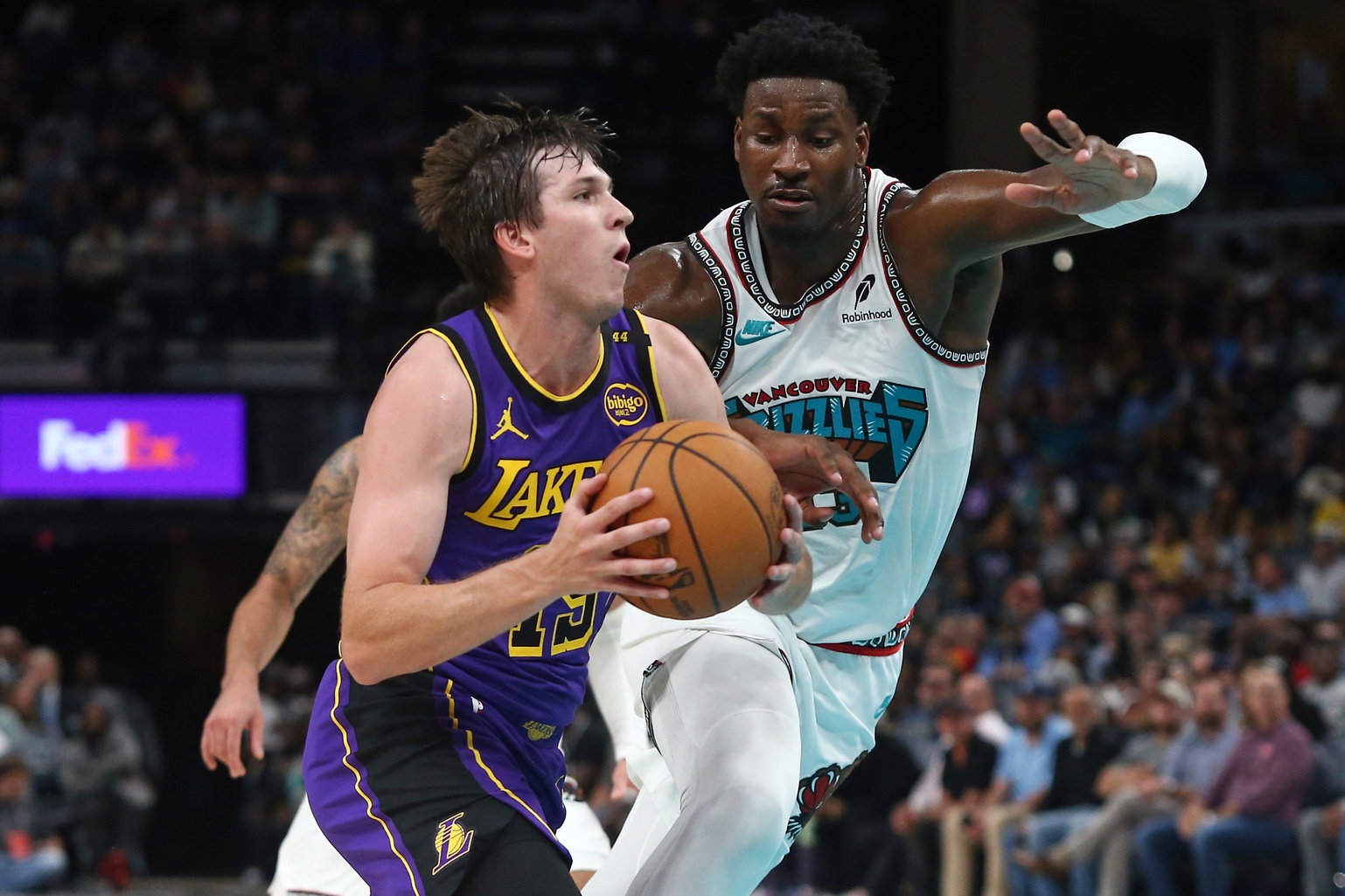 Nov 6, 2024; Memphis, Tennessee, USA; Los Angeles Lakers guard Austin Reaves (15) drives to the basket as Memphis Grizzlies forward Jaren Jackson Jr. (13) defends during the first half at FedExForum. Mandatory Credit: Petre Thomas-Imagn Images
