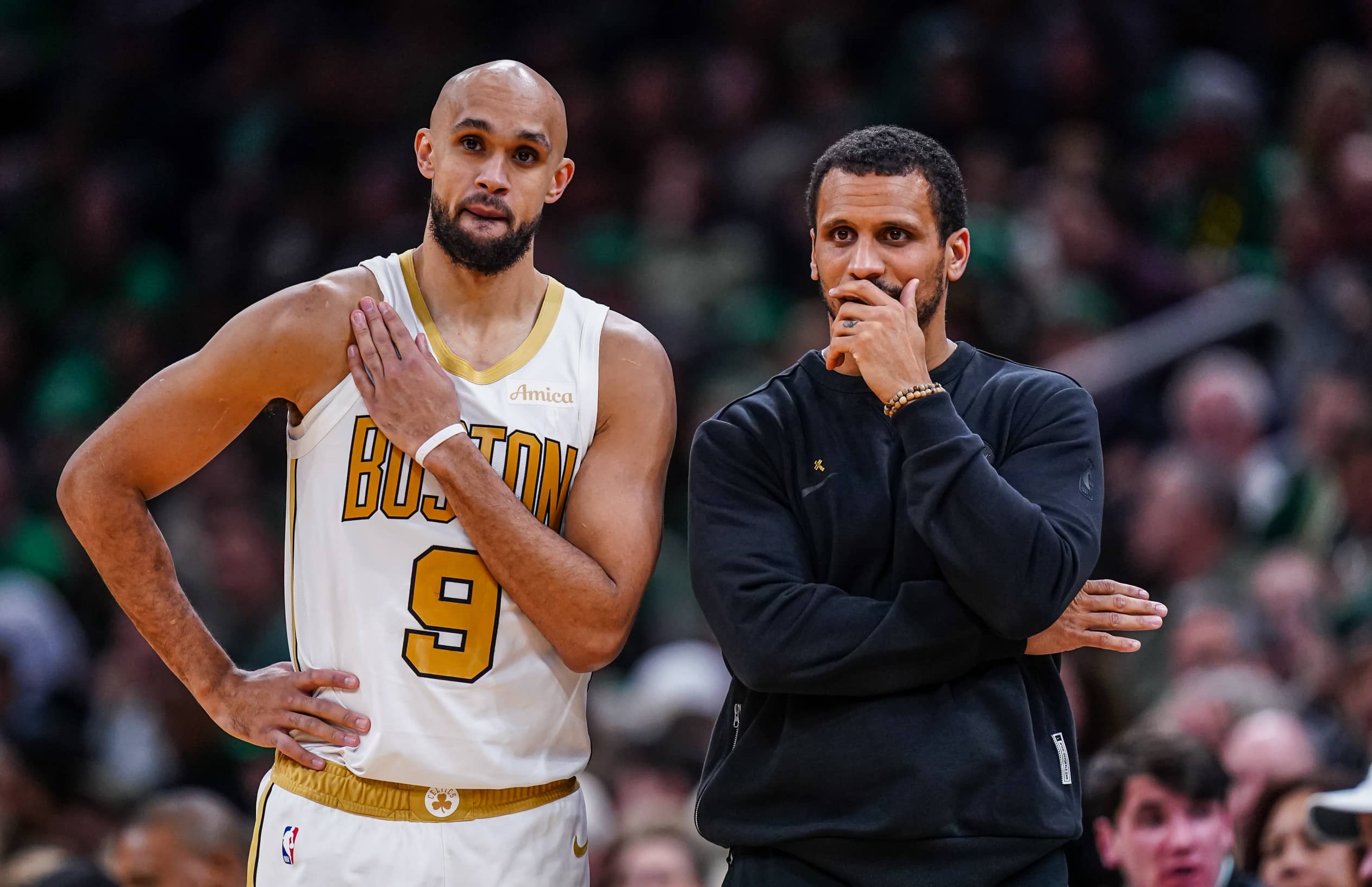 Boston Celtics head coach Joe Mazzulla talks with guard Derrick White (9) from the sideline as they take on the Miami Heat at TD Garden.