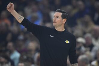 Jan 28, 2026; Cleveland, Ohio, USA; Los Angeles Lakers head coach JJ Redick calls a play in the first quarter against the Cleveland Cavaliers at Rocket Arena. Mandatory Credit: David Richard-Imagn Images