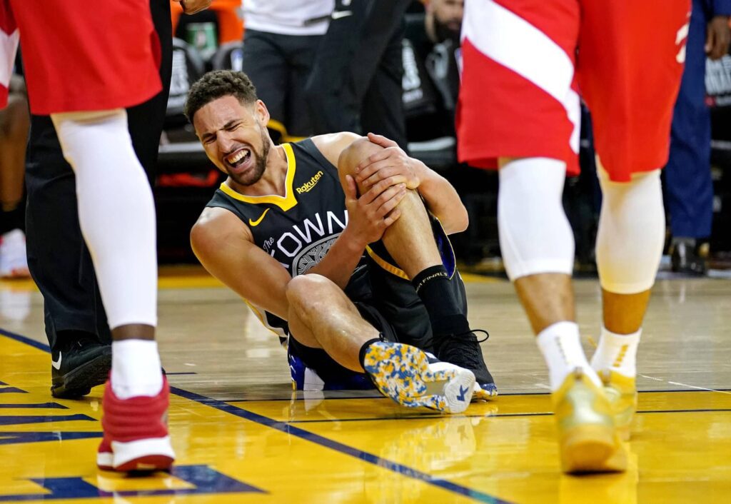 Golden State Warriors guard Klay Thompson (11) reacts after an injury during the third quarter against the Toronto Raptors in game six of the 2019 NBA Finals at Oracle Arena.