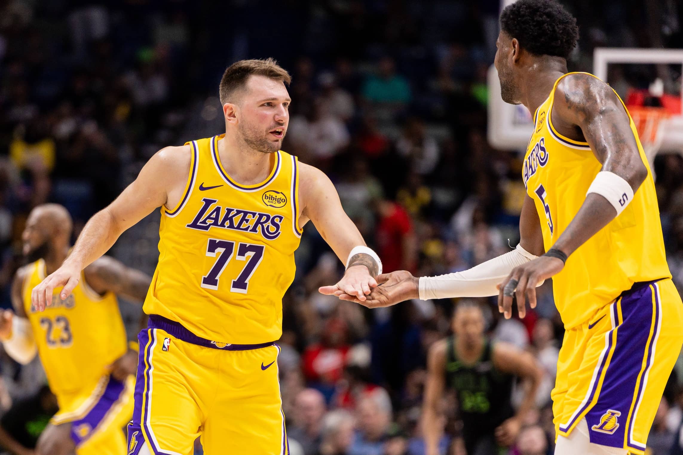 Jan 6, 2026; New Orleans, Louisiana, USA; Los Angeles Lakers forward/guard Luka Doncic (77) slaps hands with center Deandre Ayton (5) after a play against the New Orleans Pelicans during the second half at Smoothie King Center. Mandatory Credit: Stephen Lew-Imagn Images