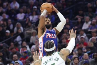 Jan 27, 2026; Philadelphia, Pennsylvania, USA; Philadelphia 76ers forward Paul George (8) shoots in front of Milwaukee Bucks guard Gary Trent Jr. (5) during the fourth quarter at Xfinity Mobile Arena. Mandatory Credit: Bill Streicher-Imagn Images