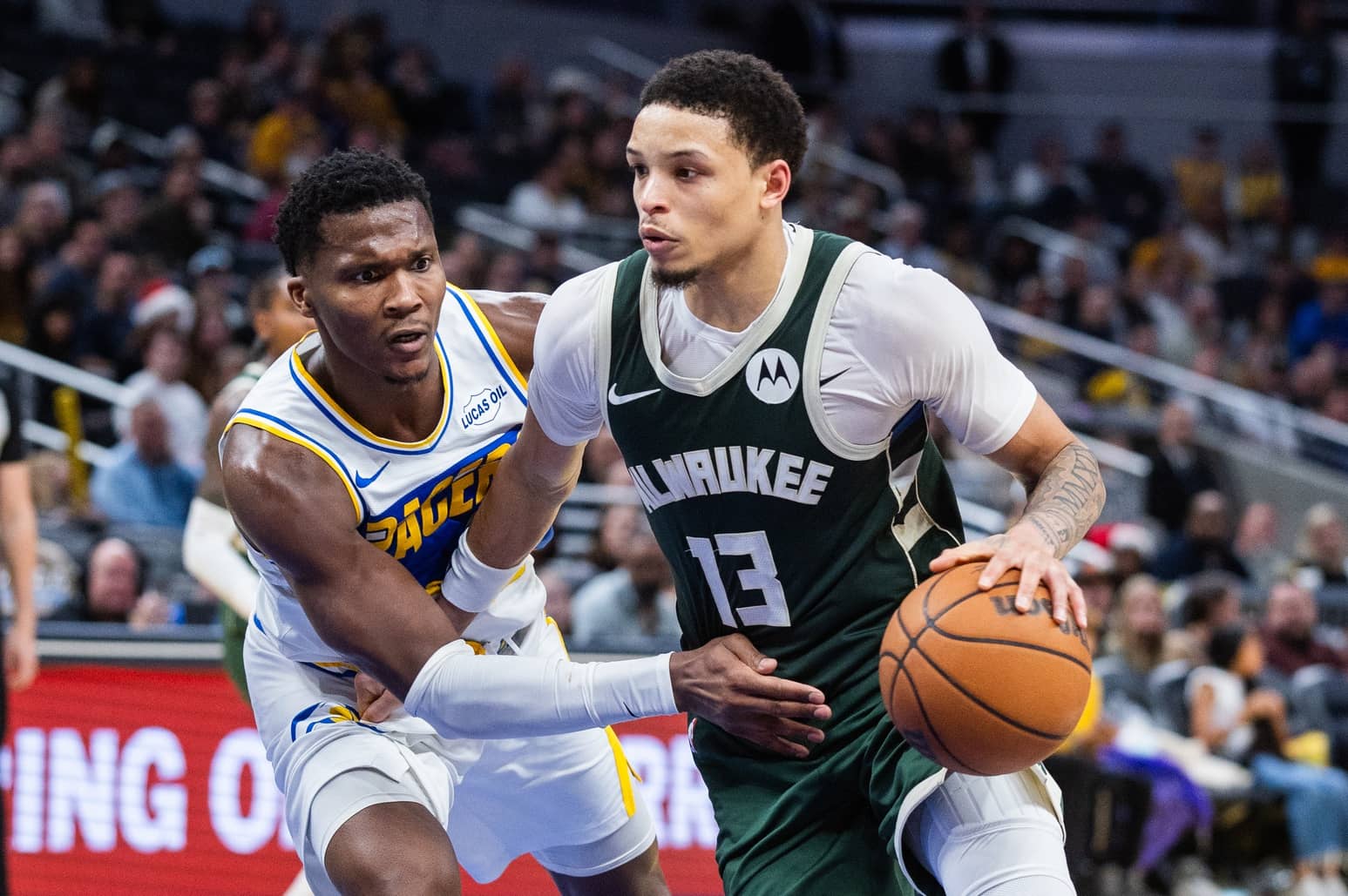 Dec 23, 2025; Indianapolis, Indiana, USA; Milwaukee Bucks guard Ryan Rollins (13) dribbles the ball while Indiana Pacers guard/forward Bennedict Mathurin (00) defends in the second half at Gainbridge Fieldhouse. Mandatory Credit: Trevor Ruszkowski-Imagn Images