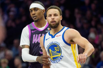 Golden State Warriors guard Stephen Curry (30) is defended by Minnesota Timberwolves forward Jaden McDaniels (3) in the fourth quarter at Target Center.