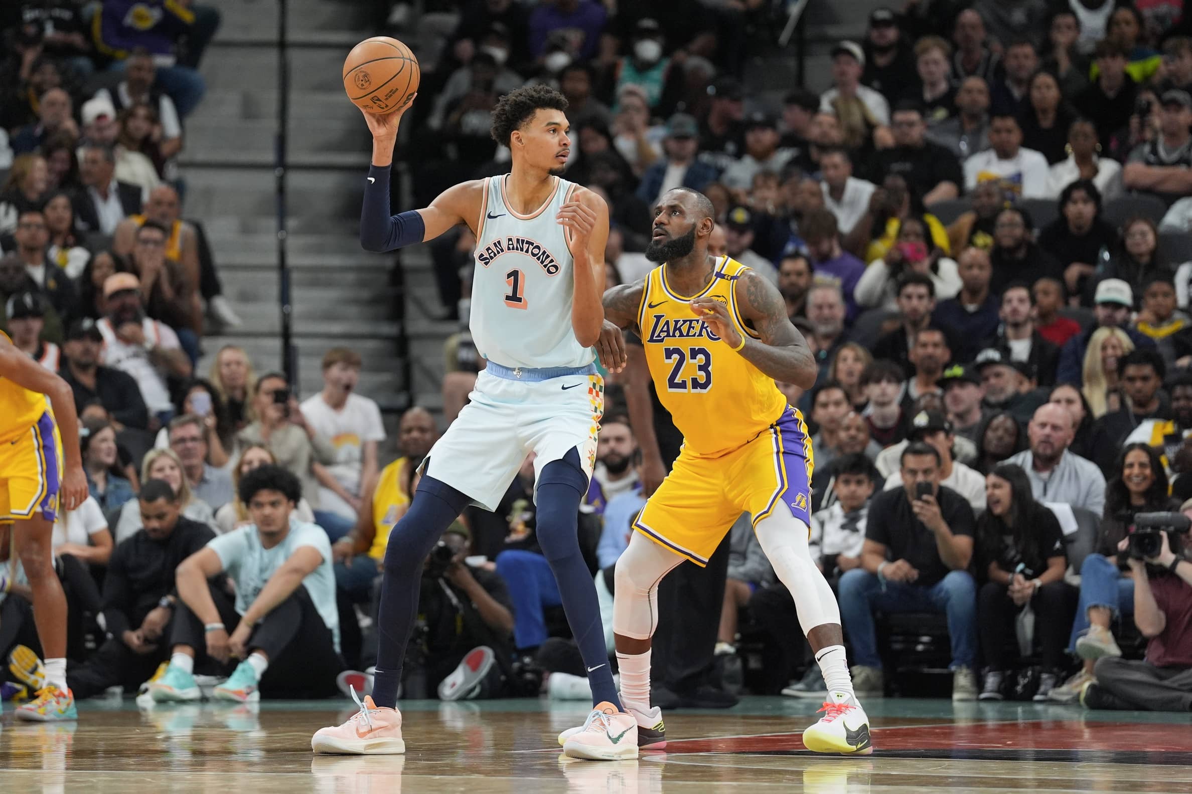 San Antonio Spurs center Victor Wembanyama (1) handles the ball in front of Los Angeles Lakers forward LeBron James (23) in the second half at Frost Bank Center.