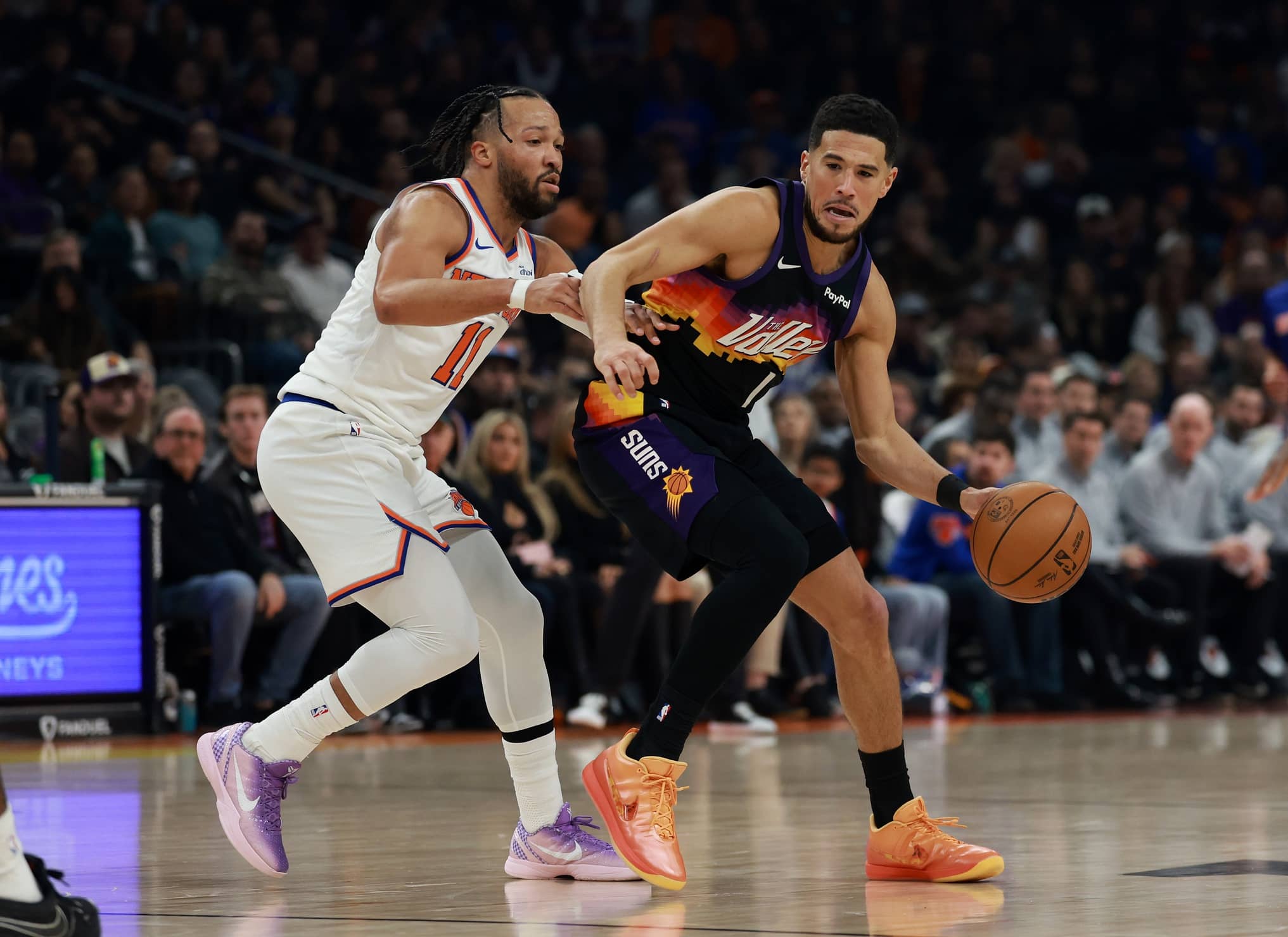 Phoenix, Arizona, USA; Phoenix Suns guard Devin Booker (1) controls the ball against New York Knicks guard Jalen Brunson (11) in the first half at Mortgage Matchup Center. Mandatory Credit: Mark J. Rebilas-Imagn Images