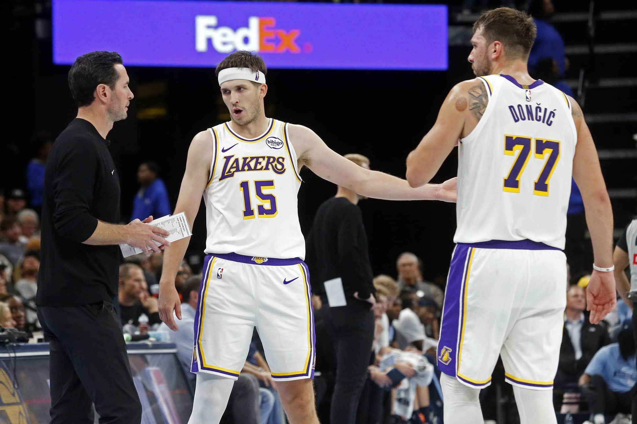 Memphis, Tennessee, USA; Los Angeles Lakers head coach JJ Redick talks with guard Austin Reaves (15) and guard Luka Doncic (77) during the fourth quarter against the Memphis Grizzlies at FedExForum. Mandatory Credit: Petre Thomas-Imagn Images