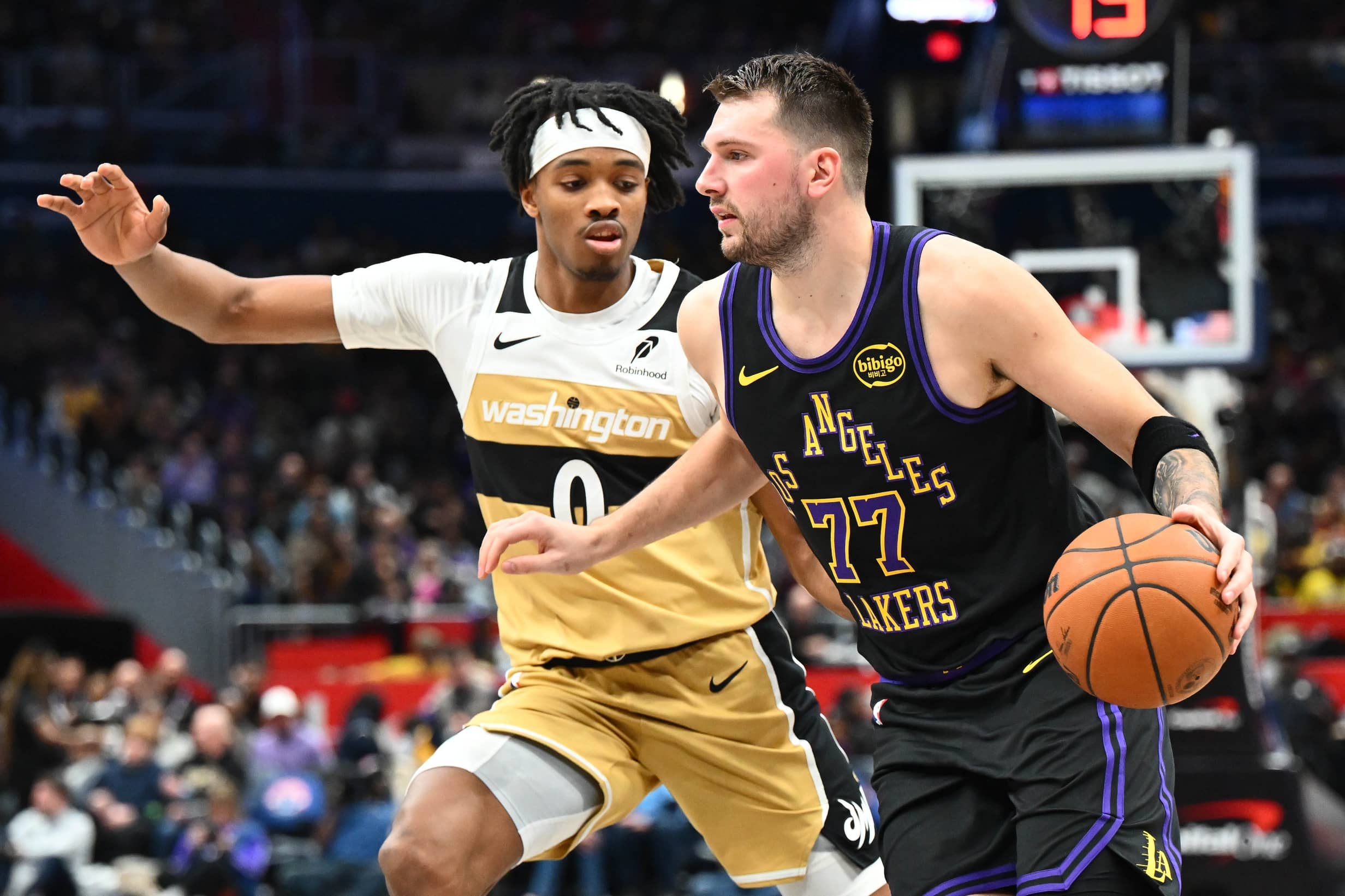 Washington, District of Columbia, USA; Los Angeles Lakers forward/guard Luka Doncic (77) dribbles as Washington Wizards guard Bilal Coulibaly (0) defends during the second half at Capital One Arena. Mandatory Credit: Brad Mills-Imagn Images