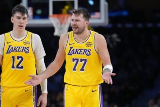Los Angeles, California, USA; Los Angeles Lakers forward Jake LaRavia (12) and guard Luka Doncic (77) react against the Charlotte Hornets in the second half at Crypto.com Arena. Mandatory Credit: Kirby Lee-Imagn Images