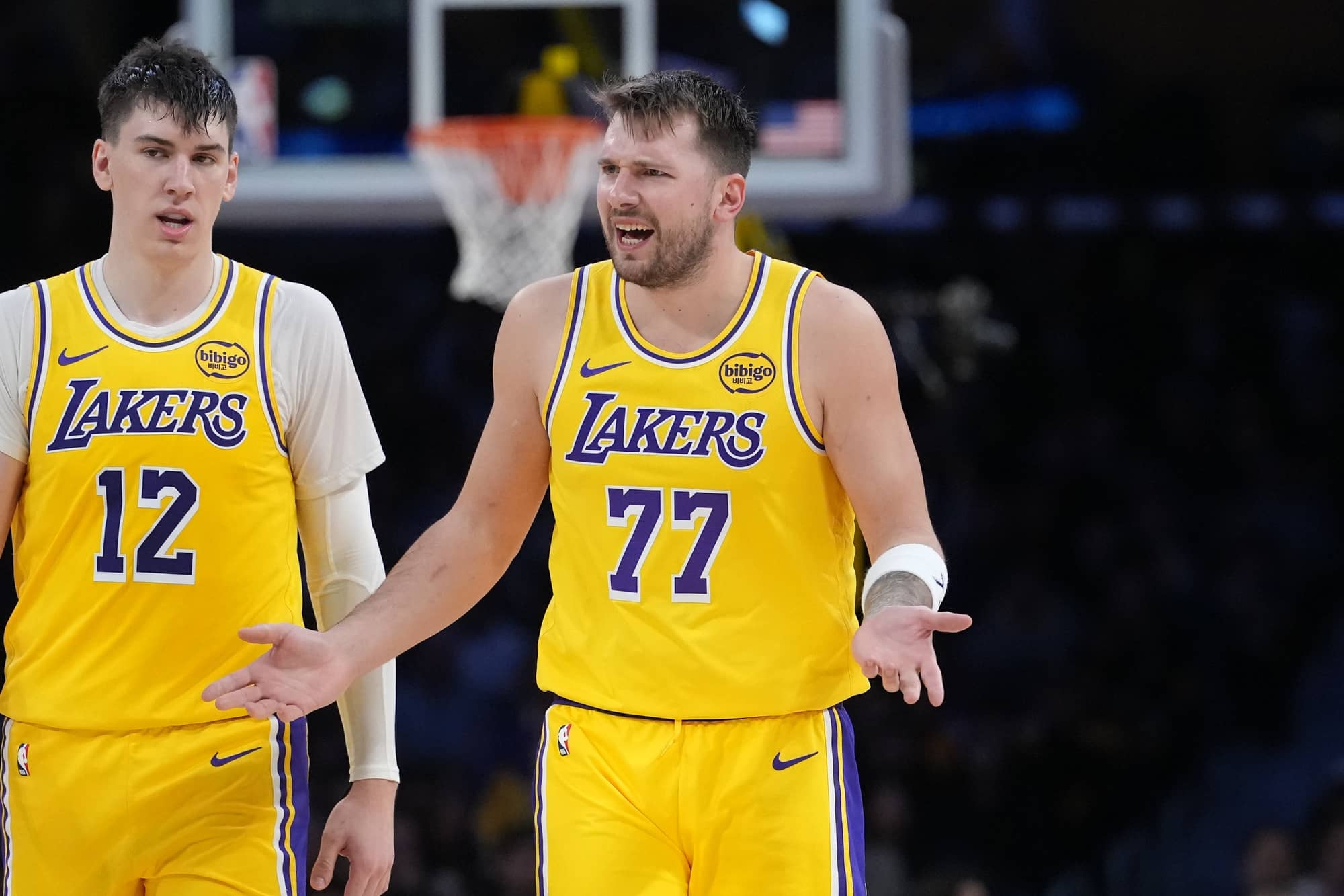 Los Angeles, California, USA; Los Angeles Lakers forward Jake LaRavia (12) and guard Luka Doncic (77) react against the Charlotte Hornets in the second half at Crypto.com Arena. Mandatory Credit: Kirby Lee-Imagn Images