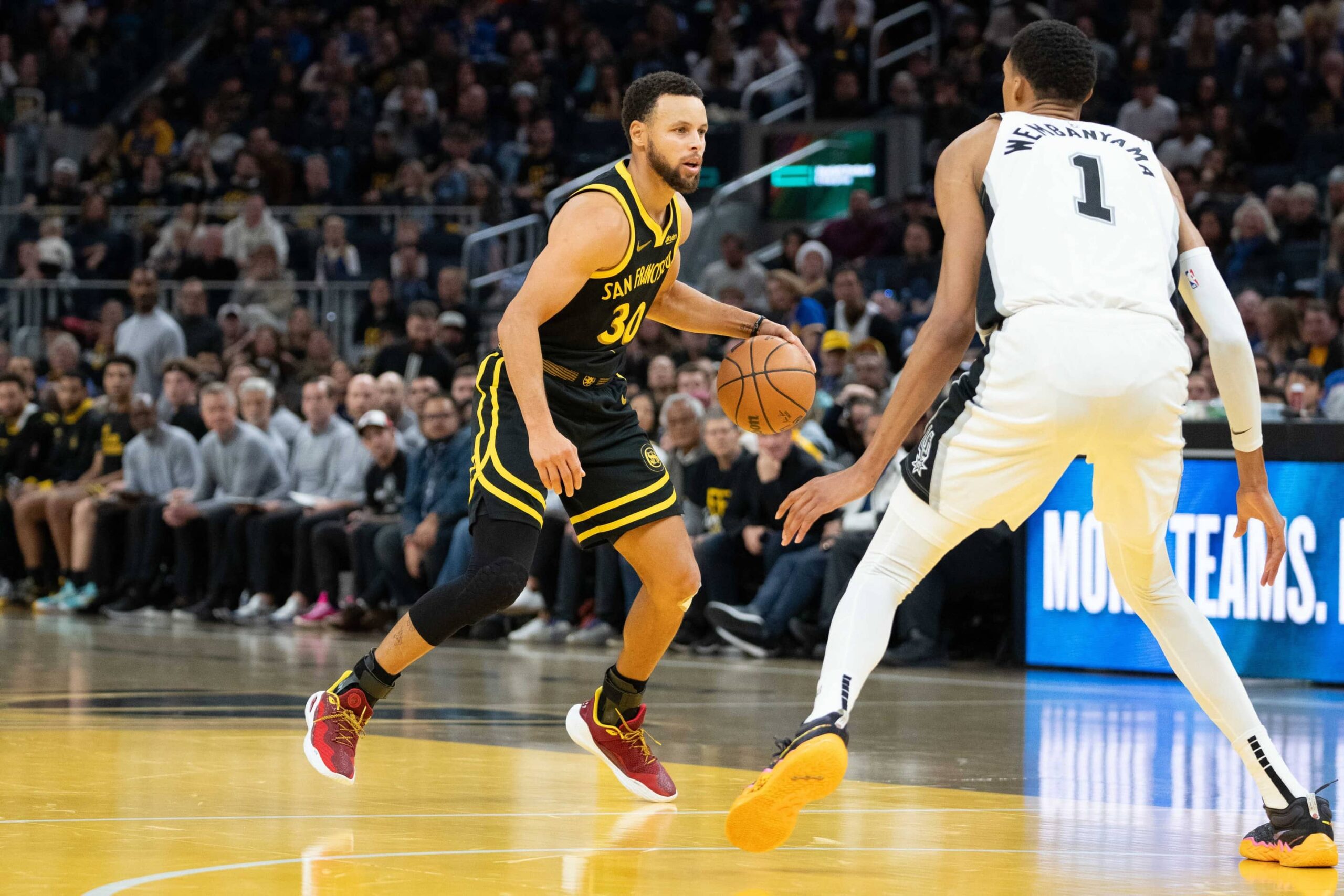 San Francisco, California, USA; Golden State Warriors guard Stephen Curry (30) dribbles the basketball against San Antonio Spurs center Victor Wembanyama (1) during the fourth quarter at Chase Center. Mandatory Credit: Kyle Terada-Imagn Images