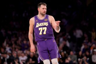 New York, New York, USA; Los Angeles Lakers guard Luka Doncic (77) points in the direction of Knicks fan Spike Lee (not pictured) after a three point shot against the New York Knicks during the third quarter at Madison Square Garden. Mandatory Credit: Brad Penner-Imagn Images