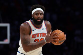 Miami, Florida, USA; New York Knicks center Mitchell Robinson (23) protects the basketball against the Miami Heat during the third quarter at Kaseya Center. Mandatory Credit: Sam Navarro-Imagn Images