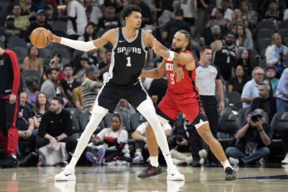 San Antonio Spurs center Victor Wembanyama (1) controls the ball while defended by Houston Rockets guard Dillon Brooks (9) during the first half at Frost Bank Center.