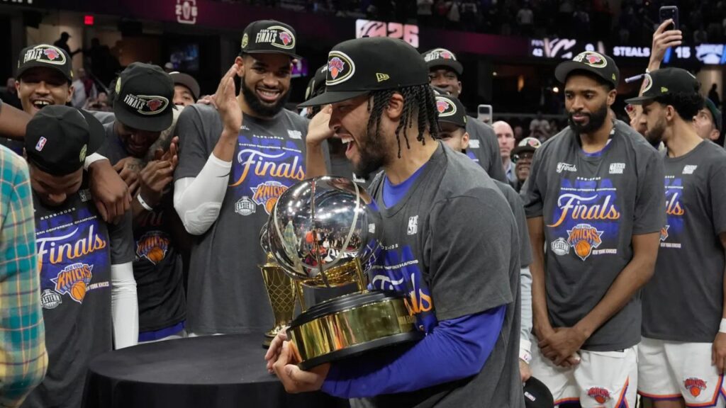 New York Knicks guard Jalen Brunson, center, holds the Eastern Conference Championship trophy after Game 4 in the Eastern Conference finals NBA basketball playoffs series against the Cleveland Cavaliers in Cleveland, Monday, May 25, 2026. (AP Photo/Sue Ogrocki)