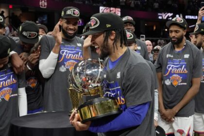 New York Knicks guard Jalen Brunson, center, holds the Eastern Conference Championship trophy after Game 4 in the Eastern Conference finals NBA basketball playoffs series against the Cleveland Cavaliers in Cleveland, Monday, May 25, 2026. (AP Photo/Sue Ogrocki)