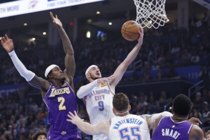Nov 12, 2025; Oklahoma City, Oklahoma, USA; Oklahoma City Thunder guard Alex Caruso (9) goes up for a basket beside Los Angeles Lakers forward Jarred Vanderbilt (2) during the second quarter at Paycom Center. Mandatory Credit: Alonzo Adams-Imagn Images