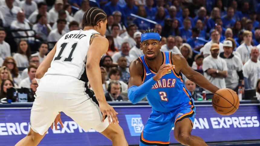 Oklahoma City, Oklahoma, USA; Oklahoma City Thunder guard Shai Gilgeous-Alexander (2) looks to pass as San Antonio Spurs forward Carter Bryant (11) defends during the third quarter during game two of the western conference finals for the 2026 NBA playoffs at Paycom Center. Mandatory Credit: Brett Rojo-Imagn Images