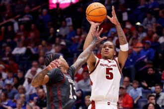 NASHVILLE, TENNESSEE - MARCH 13: Darius Acuff Jr. #5 of the Arkansas Razorbacks shoots the ball over Tae Davis #13 of the Oklahoma Sooners during the first half in the quarterfinal game of the 2026 SEC Men's Basketball Tournament at Bridgestone Arena on March 13, 2026 in Nashville, Tennessee.