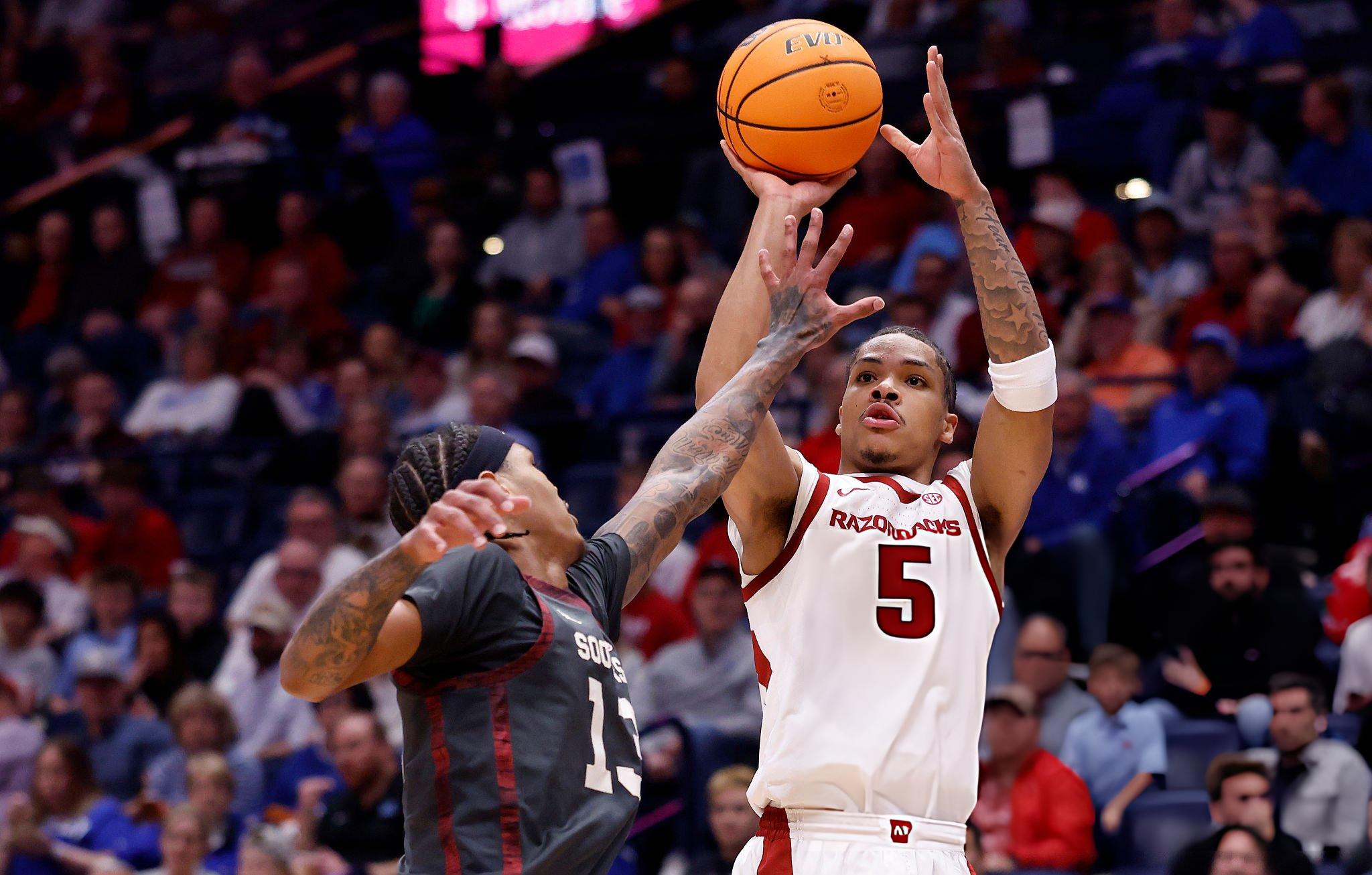 NASHVILLE, TENNESSEE - MARCH 13: Darius Acuff Jr. #5 of the Arkansas Razorbacks shoots the ball over Tae Davis #13 of the Oklahoma Sooners during the first half in the quarterfinal game of the 2026 SEC Men's Basketball Tournament at Bridgestone Arena on March 13, 2026 in Nashville, Tennessee.
