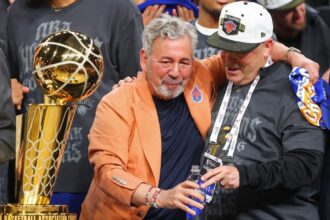 SAN ANTONIO, TEXAS - JUNE 13: New York Knicks owner James Dolan and president Leon Rose celebrate behind the Larry O'Brien Championship Trophy after their team defeated the San Antonio Spurs in Game Five of the 2026 NBA Finals at Frost Bank Center on June 13, 2026 in San Antonio, Texas. (Photo by Gregory Shamus/Getty Images)