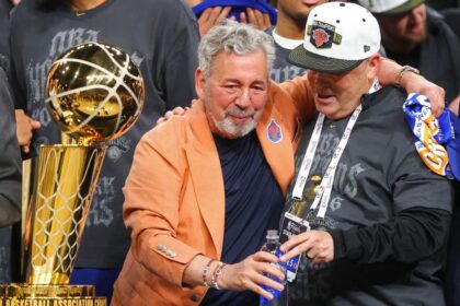 SAN ANTONIO, TEXAS - JUNE 13: New York Knicks owner James Dolan and president Leon Rose celebrate behind the Larry O'Brien Championship Trophy after their team defeated the San Antonio Spurs in Game Five of the 2026 NBA Finals at Frost Bank Center on June 13, 2026 in San Antonio, Texas. (Photo by Gregory Shamus/Getty Images)
