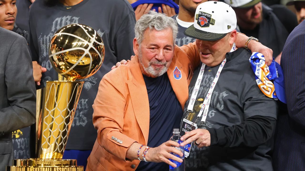 SAN ANTONIO, TEXAS - JUNE 13: New York Knicks owner James Dolan and president Leon Rose celebrate behind the Larry O'Brien Championship Trophy after their team defeated the San Antonio Spurs in Game Five of the 2026 NBA Finals at Frost Bank Center on June 13, 2026 in San Antonio, Texas. (Photo by Gregory Shamus/Getty Images)