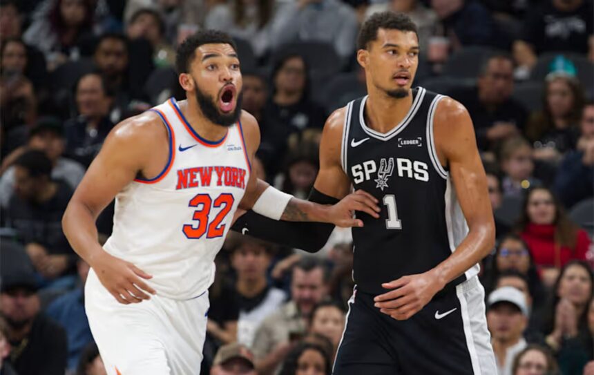 San Antonio Spurs center Victor Wembanyama (1) guards New York Knicks center Karl-Anthony Towns during the second half of an NBA basketball game, Wednesday, Dec. 31, 2025, in San Antonio. (AP Photo/Darren Abate)