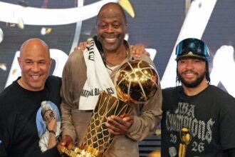 SAN ANTONIO, TX - JUNE 13: Assistant Coach Rick Brunson, Patrick Ewing, Jalen Brunson #11 of the New York Knicks pose for a photo with the Larry O'Brien Championship Trophy during Game Five of the 2026 NBA Finals on June 13, 2026 at Frost Bank Center in San Antonio, Texas. (Photo by Jesse D. Garrabrant /NBAE via Getty Images)