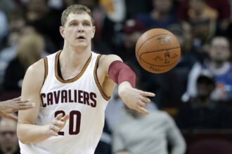 Cleveland Cavaliers' Timofey Mozgov, from Russia, passes against the Indiana Pacers in the first half of an NBA basketball game Monday, Feb. 29, 2016, in Cleveland.